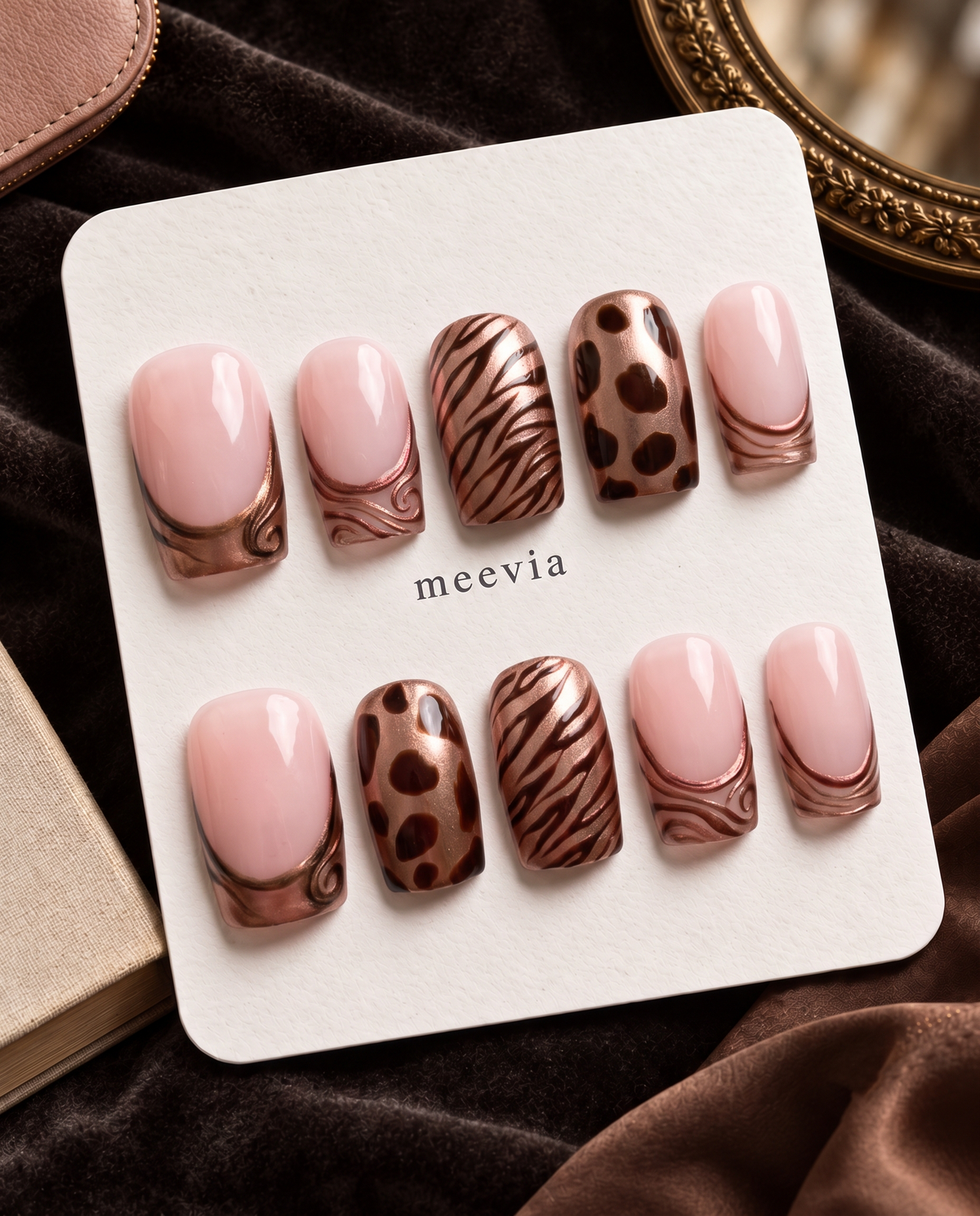 Bronze metallic French tip press-on nails with pink polish, zebra stripes, and brown animal print accents