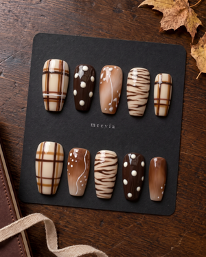 Brown plaid and abstract print press-on nails with glossy cream, caramel, and chocolate designs