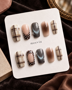 Brown plaid, nude, charcoal, and polka dot press-on nails displayed on a Meevia card