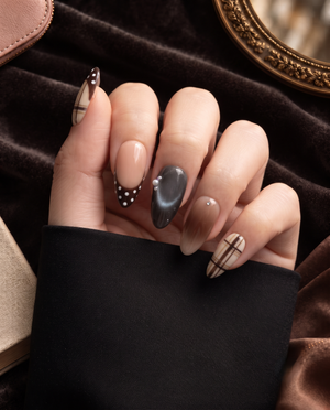 Brown plaid, nude, charcoal, and polka dot press-on nails displayed on a Meevia card