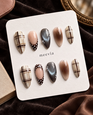 Brown plaid, nude, charcoal, and polka dot press-on nails displayed on a Meevia card