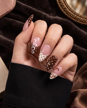 Brown and pink press-on nails with polka dots, French tips, and swirl designs