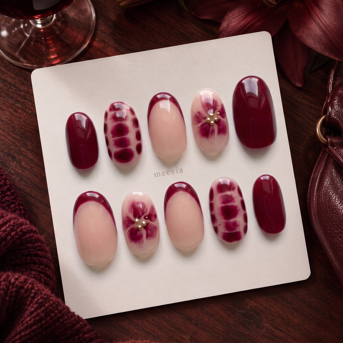 Burgundy and nude pink floral chrome press-on nails with gold embellishments