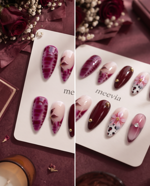 Burgundy and pink floral cow print press-on nails with glossy finish and gold embellishments