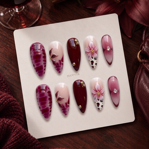 Burgundy and pink floral cow print press-on nails with glossy finish and gold embellishments
