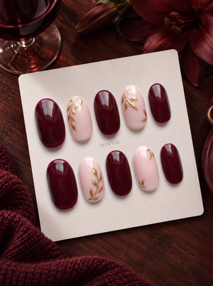 Burgundy and pink press-on nails with glossy finish and gold leaf vine details