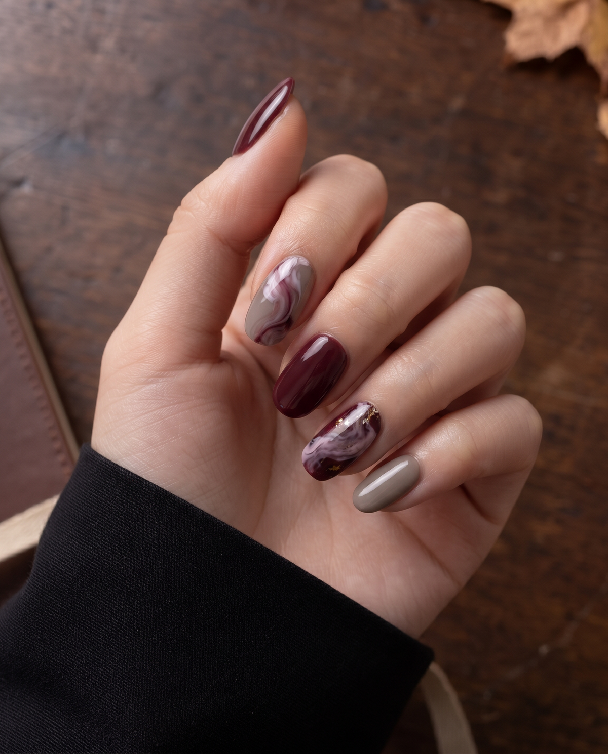 Burgundy and taupe glossy marble press-on nails with mauve swirls and gold flecks