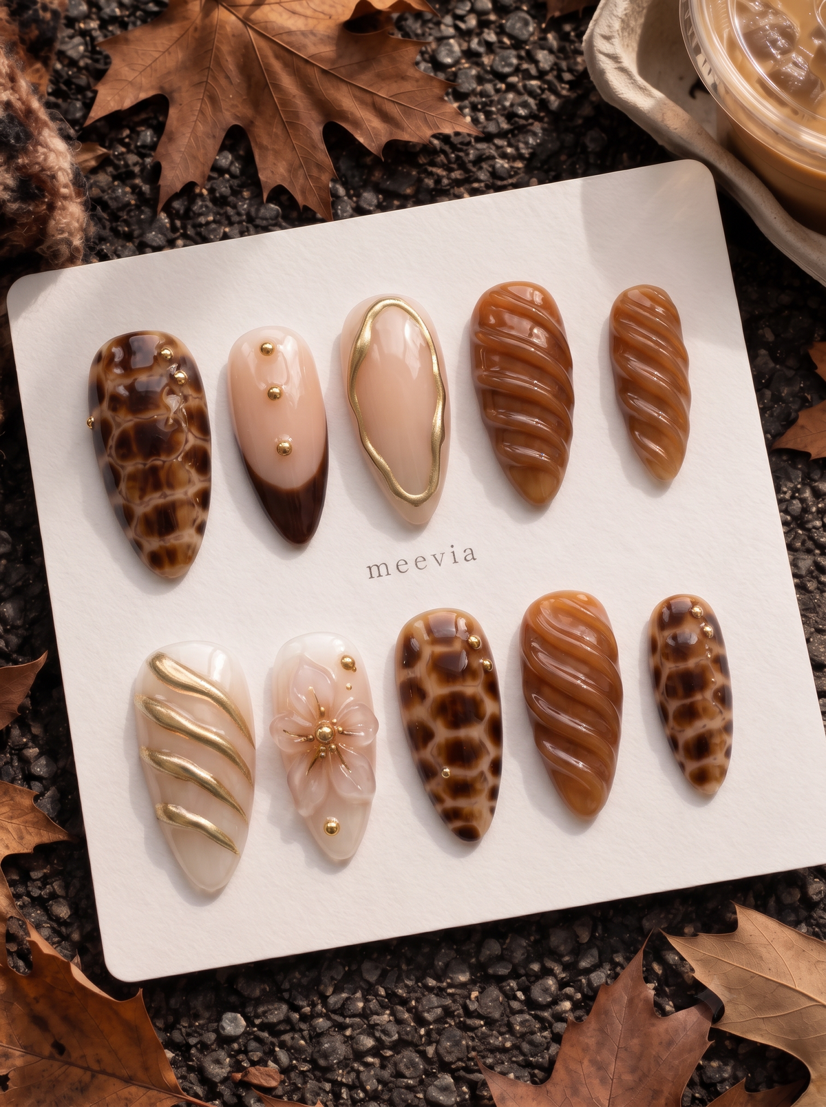 Caramel and brown tortoiseshell floral press-on nails with glossy swirls and gold accents