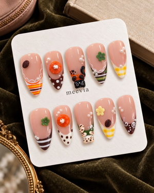 Glossy pink press-on nails with cat, dessert, flower, pearl, and gingham motifs