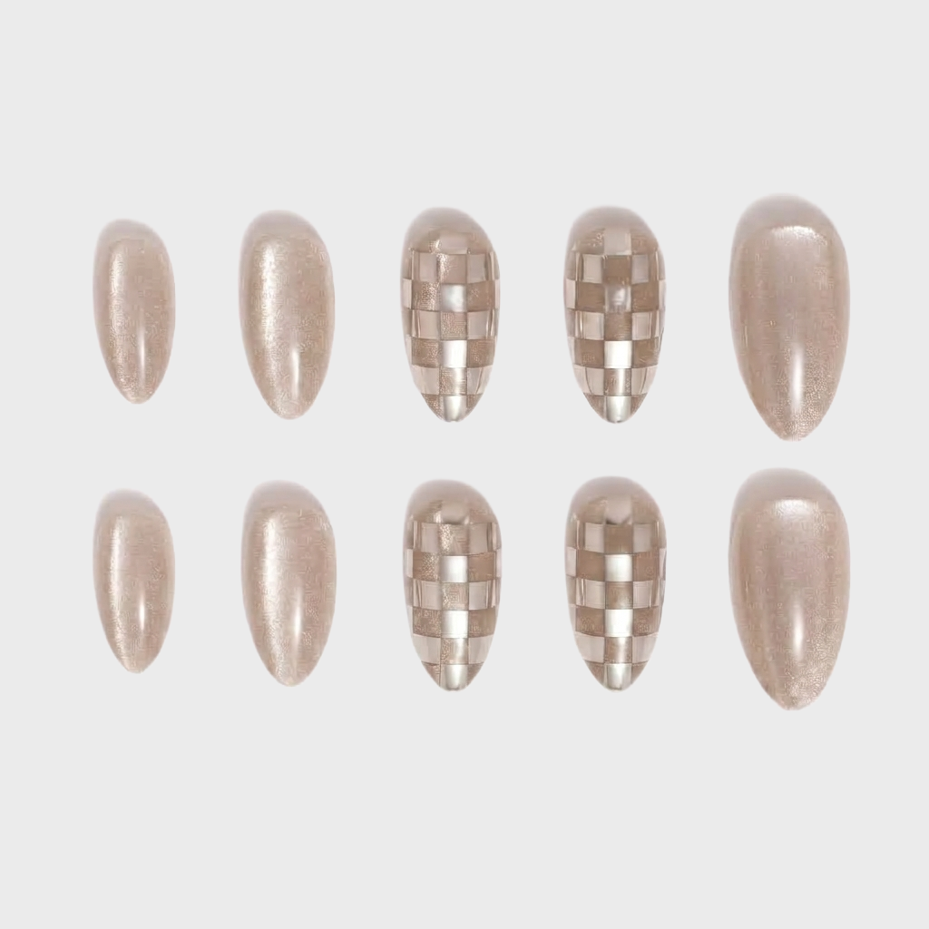 Champagne colored press-on nails featuring a mix of solid shimmer nails and checkered pattern accent nails.