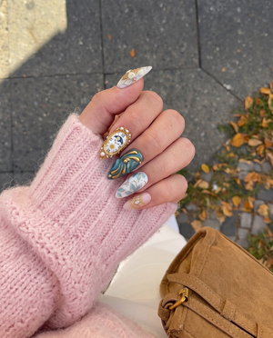 A set of stiletto press-on nails featuring clockwork, floral, and butterfly designs with gold accents.