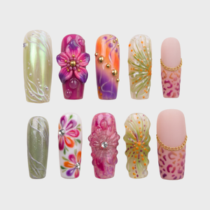 A set of press-on nails featuring floral 3D accents, leopard print patterns, rhinestones, and gold chain details.