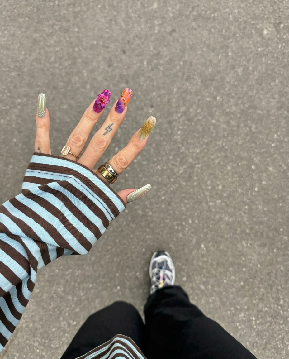 A set of press-on nails featuring floral 3D accents, leopard print patterns, rhinestones, and gold chain details.