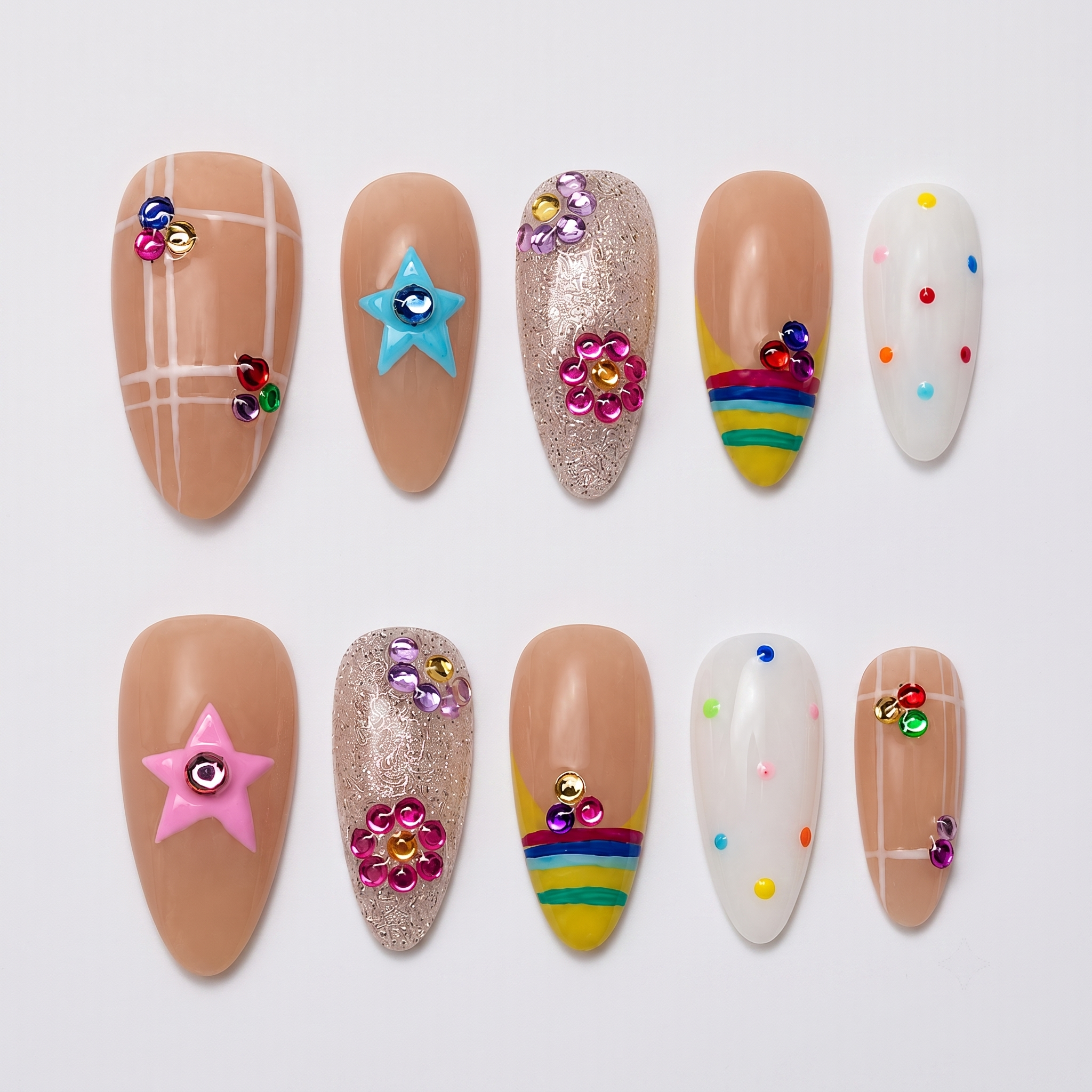 A set of press-on nails featuring nude bases with grid patterns, rainbow tips, glitter, and colorful 3D star and flower charms.