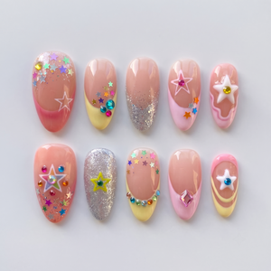A set of pastel press-on nails featuring colorful star charms, rhinestone accents, and glitter French tips.
