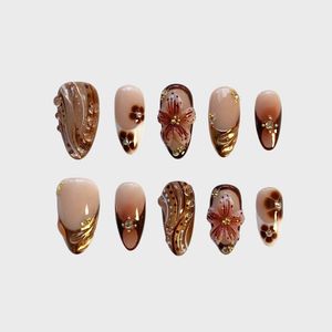 Brown floral press-on nails decorated with gold accents and clear crystals.