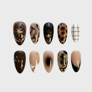 Set of brown press-on nails featuring marble, leopard print, grid patterns, and gold celestial charms.