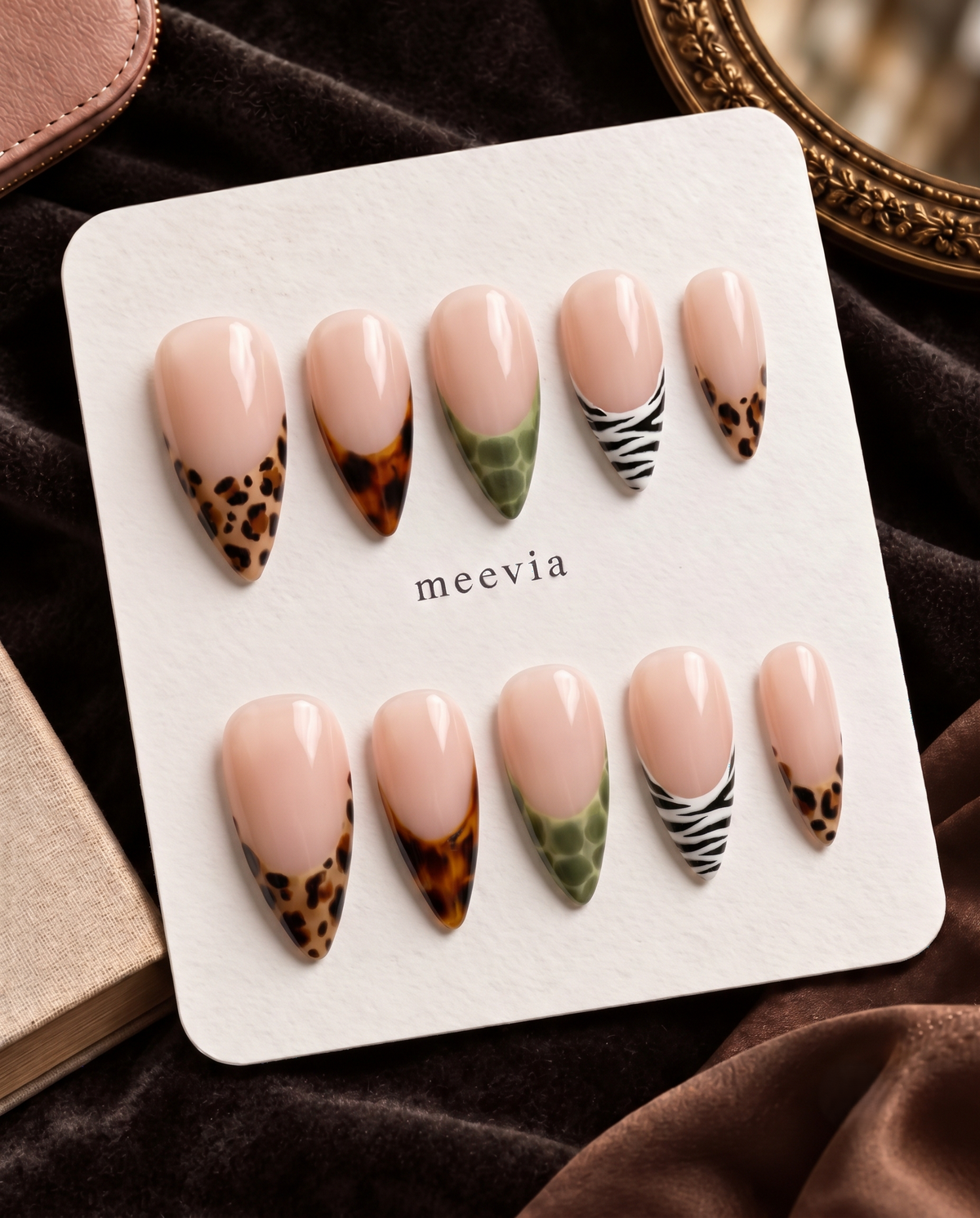 Glossy nude press-on nails with mixed tortoiseshell, olive, and zebra print French tips