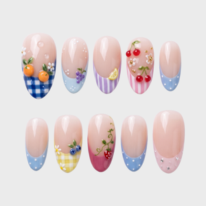 A set of press-on nails featuring gingham patterns, fruit motifs like oranges and cherries, and French tips on a white background.