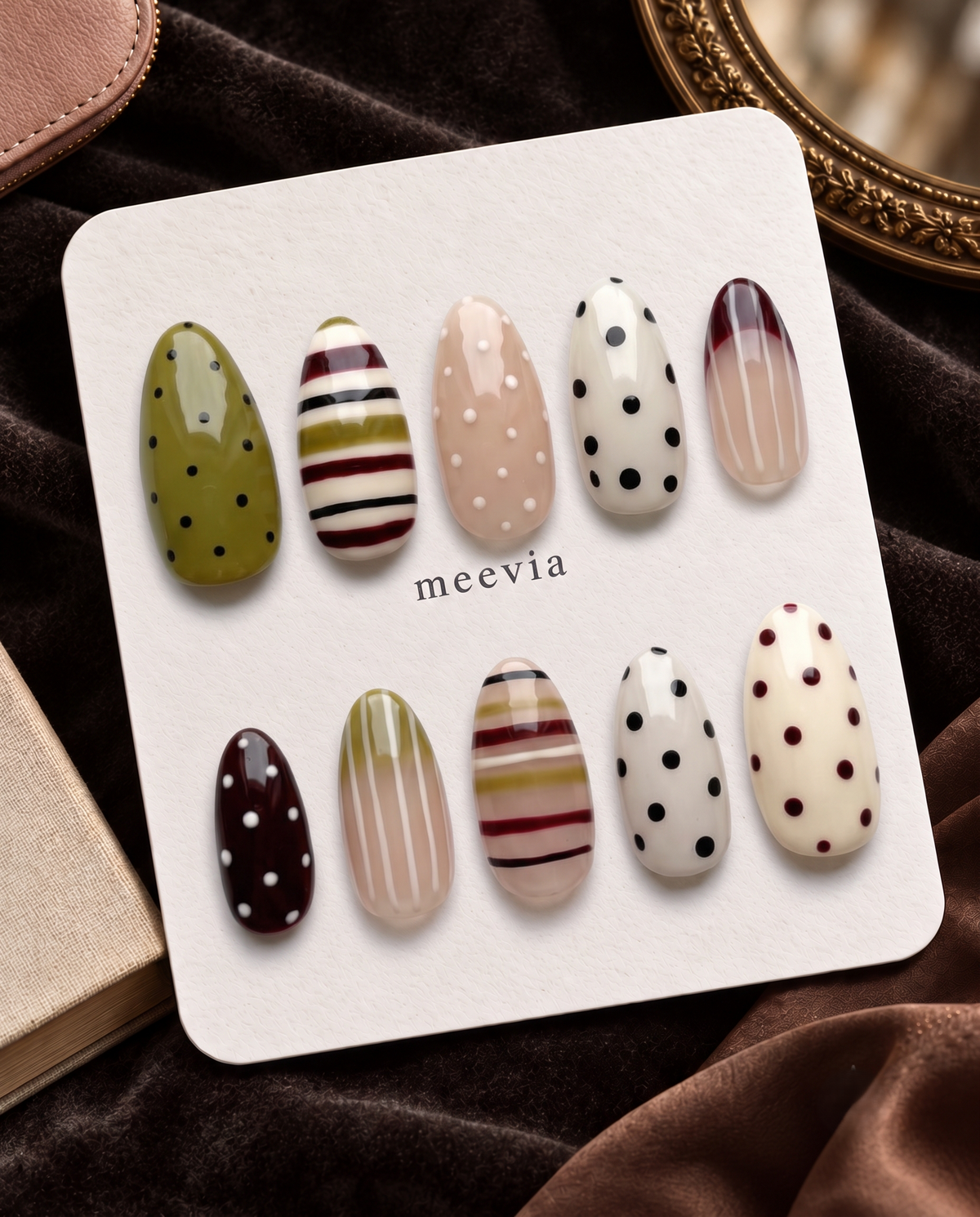 Mixed-pattern neutral press-on nails with olive, cream, nude, burgundy, black stripes and polka dots