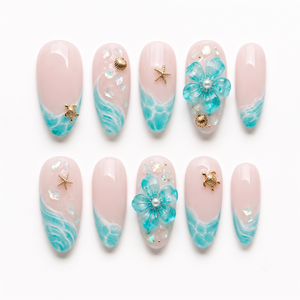 A set of sheer pink press-on nails featuring turquoise ocean wave designs, gold sea turtle and starfish charms, and 3D blue flowers with pearl details.