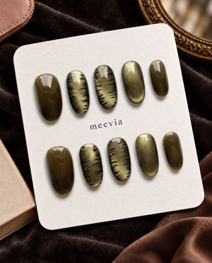 Olive cat-eye and black tiger-print press-on nails displayed on a white card