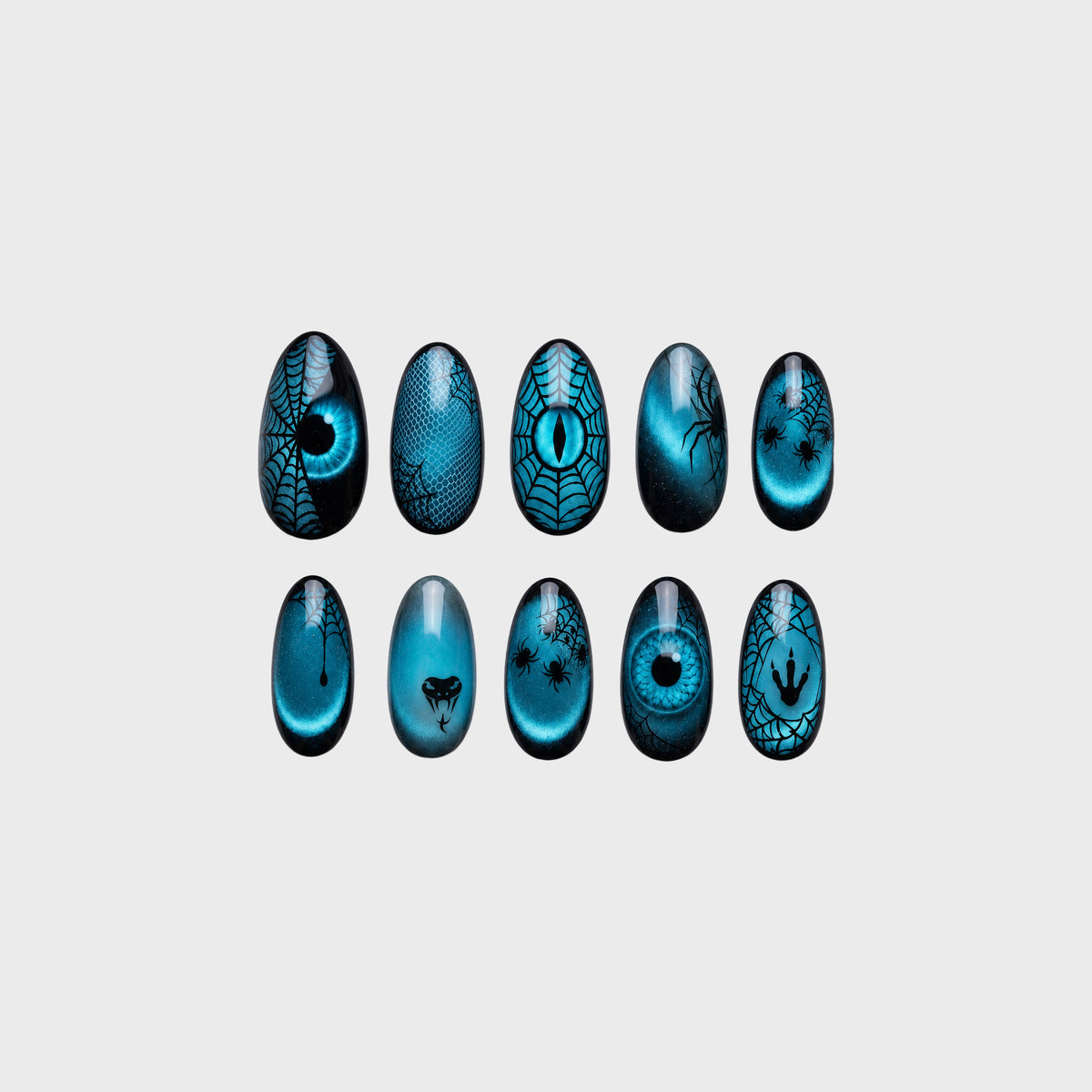 Teal cat-eye press-on nails with black spiderwebs, spiders, snake motif, claw marks, and reptile eye designs.