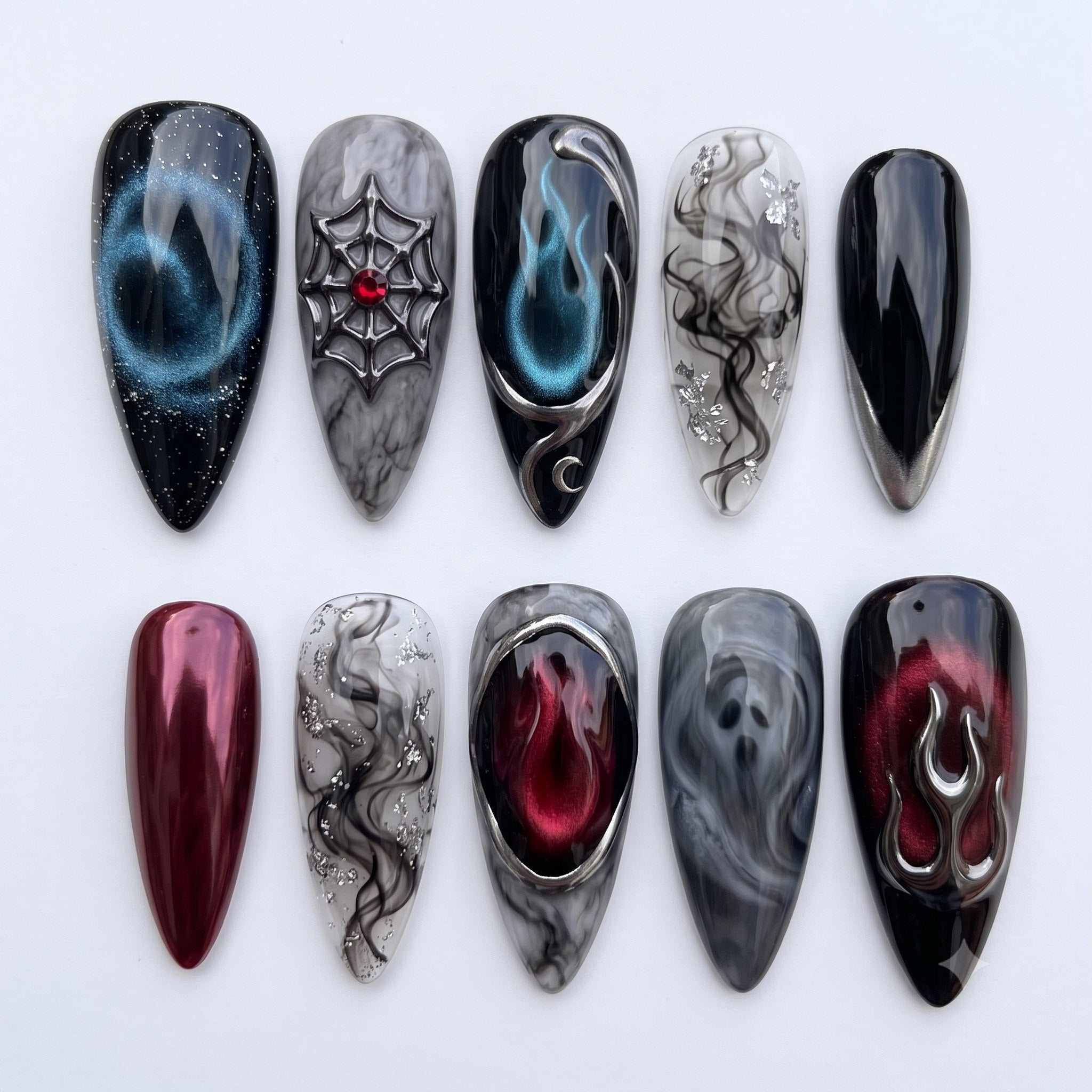 Gothic style press-on nails featuring black and red designs with 3D silver flames, a spiderweb, smoke effects, and a ghost face.