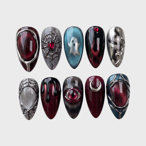 A set of gothic-themed press-on nails featuring a red eye, a silver ghost, spiderwebs, and a crescent moon with 3D metallic accents.