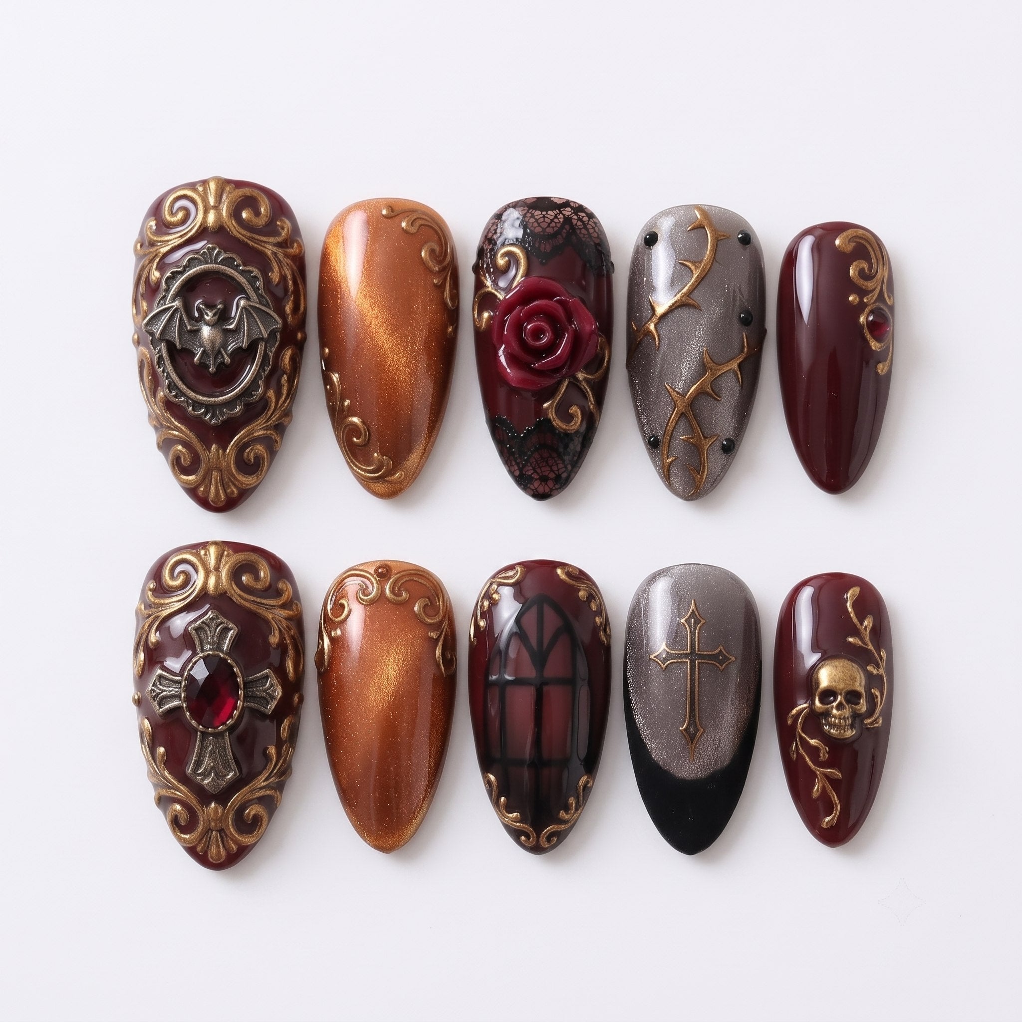 A set of gothic-themed press-on nails featuring burgundy, orange, and gray colors with gold bat, skull, rose, and cross embellishments.