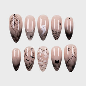 A set of spooky Halloween-themed press-on nails featuring black smoke gradients, ghosts, spider webs, and bats on a nude base.