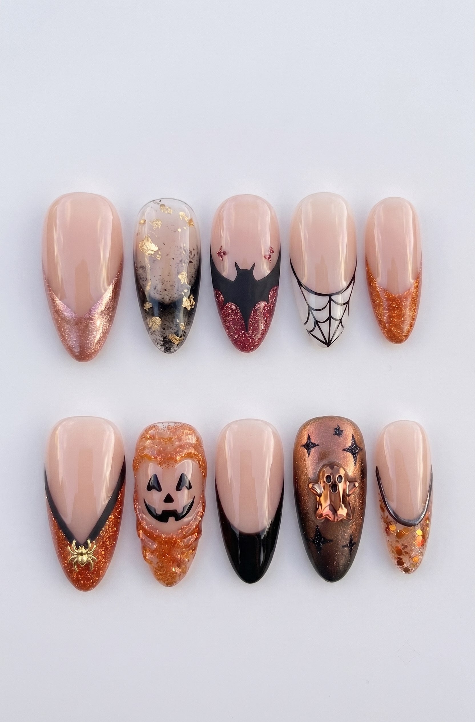 A set of Halloween-themed press-on nails featuring jack-o'-lanterns, ghosts, bats, and spiderwebs.