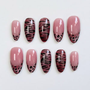 Mauve press-on nails featuring a mix of tiger stripe patterns and leopard print french tips.