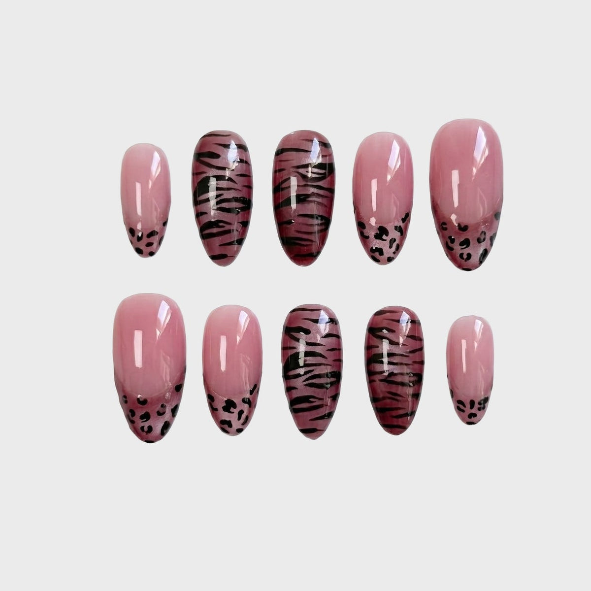 Mauve press-on nails featuring a mix of tiger stripe patterns and leopard print french tips.