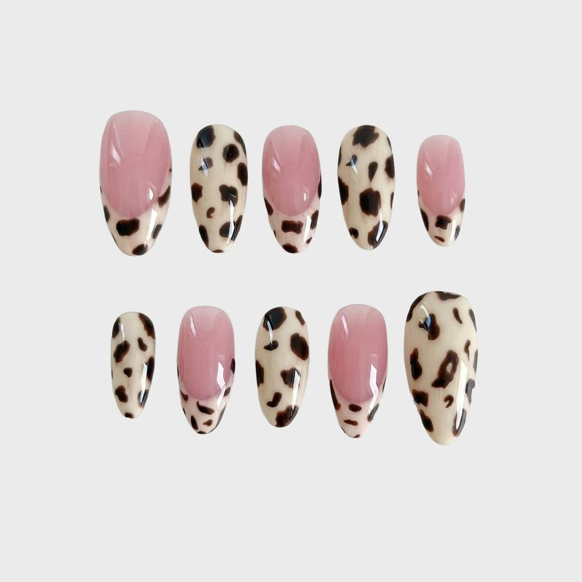 A set of press-on nails featuring leopard print patterns and French tip designs in pink and cream colors.