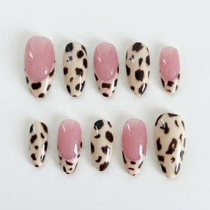 A set of press-on nails featuring leopard print patterns and French tip designs in pink and cream colors.
