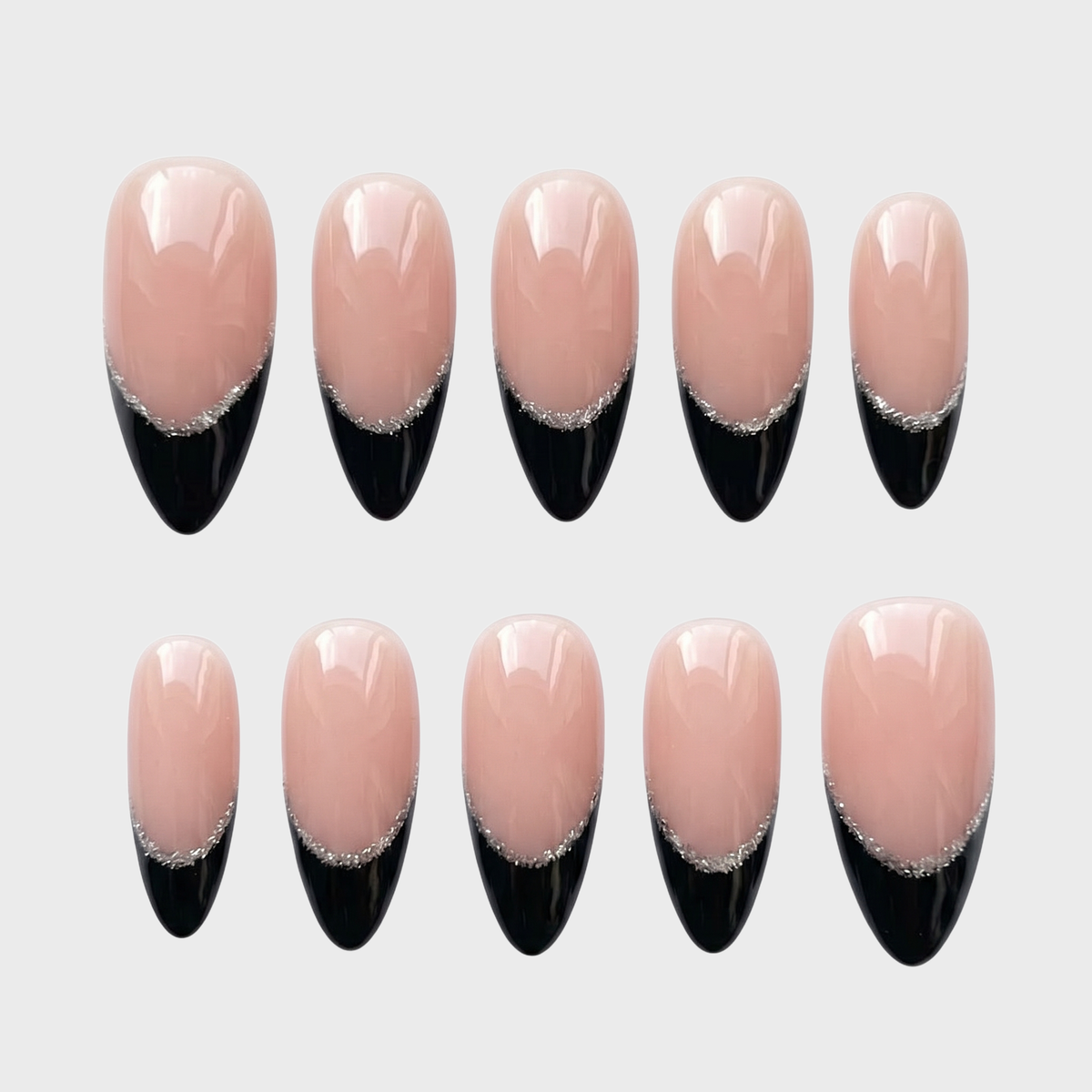 Almond shaped press-on nails featuring a nude base with black french tips and silver glitter accents.