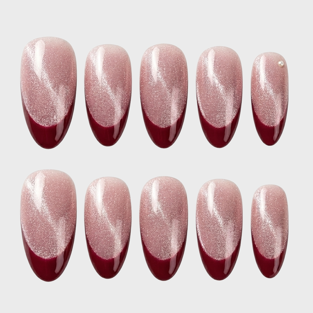 Burgundy cat eye French tip press-on nails with a single pearl accent.