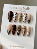 Stiletto-shaped black press-on nails with silver 3D molten metal nail art design