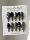 Stiletto-shaped silver chrome and black press-on nail set with 3D metallic liquid-metal art