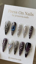 Long stiletto press-on nails with purple jelly base, 3D silver molten art, and iridescent butterfly wings.