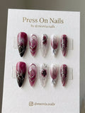 Long stiletto press-on nail set featuring deep wine ombre, black script, and 3D silver chrome accents.