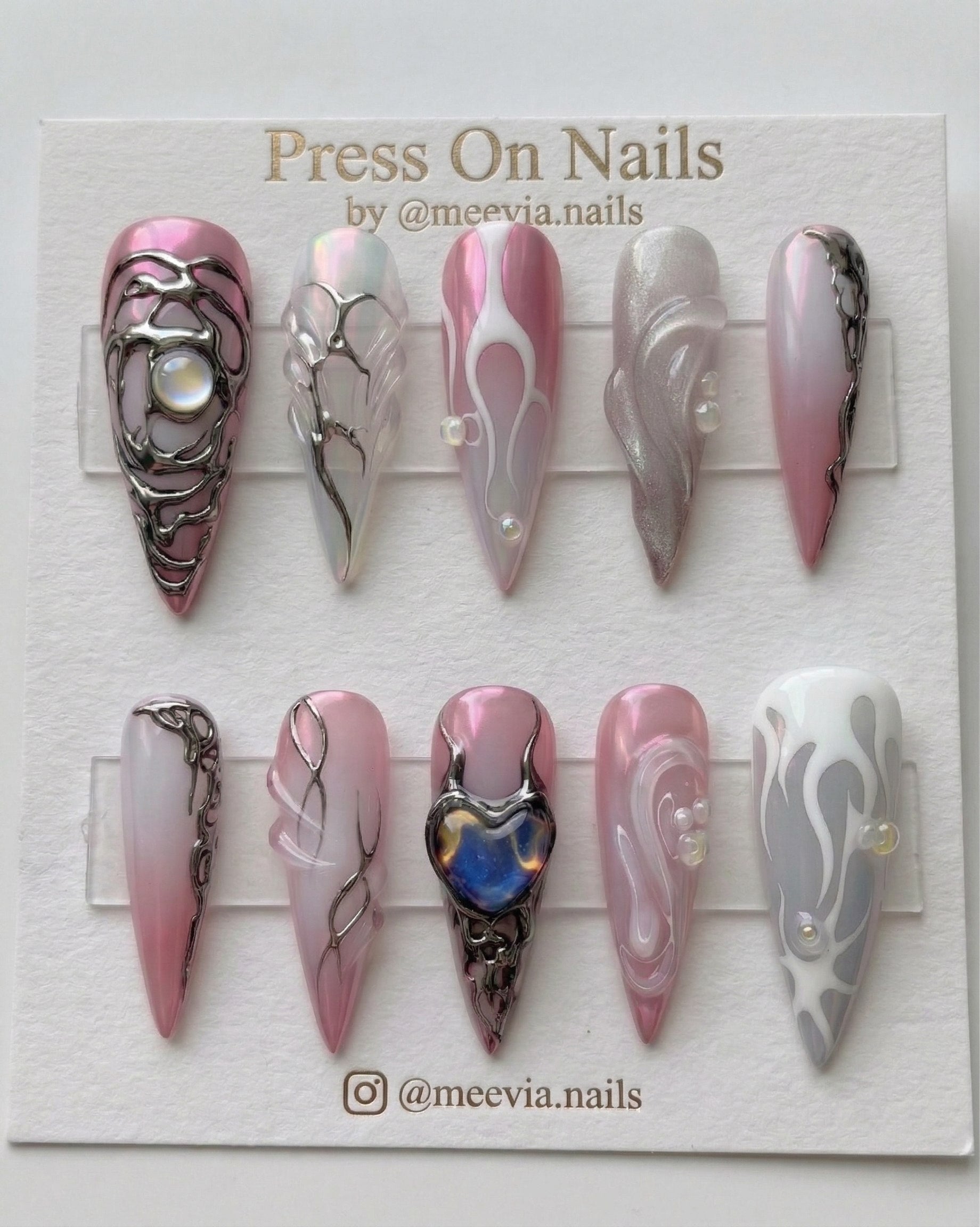 Long stiletto pink chrome press-on nails with 3D silver liquid metal art and iridescent heart charm.