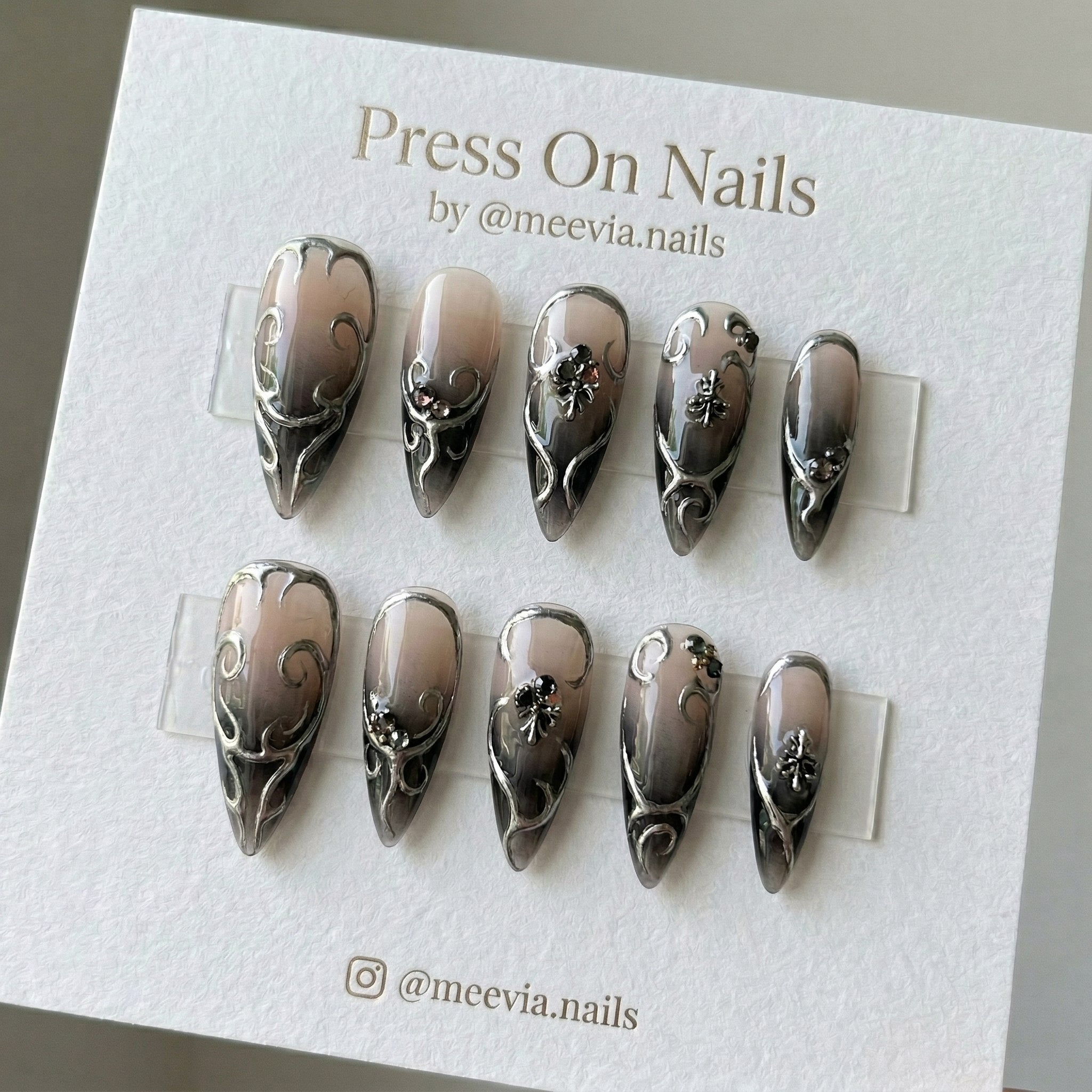 Stiletto-shaped dark ombre press-on nail set with 3D silver filigree and gemstone accents