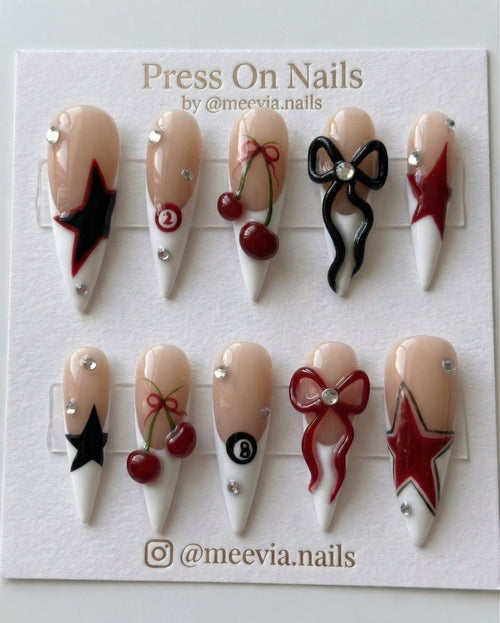Long stiletto press-on nail set with 3D cherries, bows, stars, and billiard ball motifs.