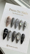 Stiletto-shaped gothic press-on nail set with silver 3D art, chains, and iridescent gems.