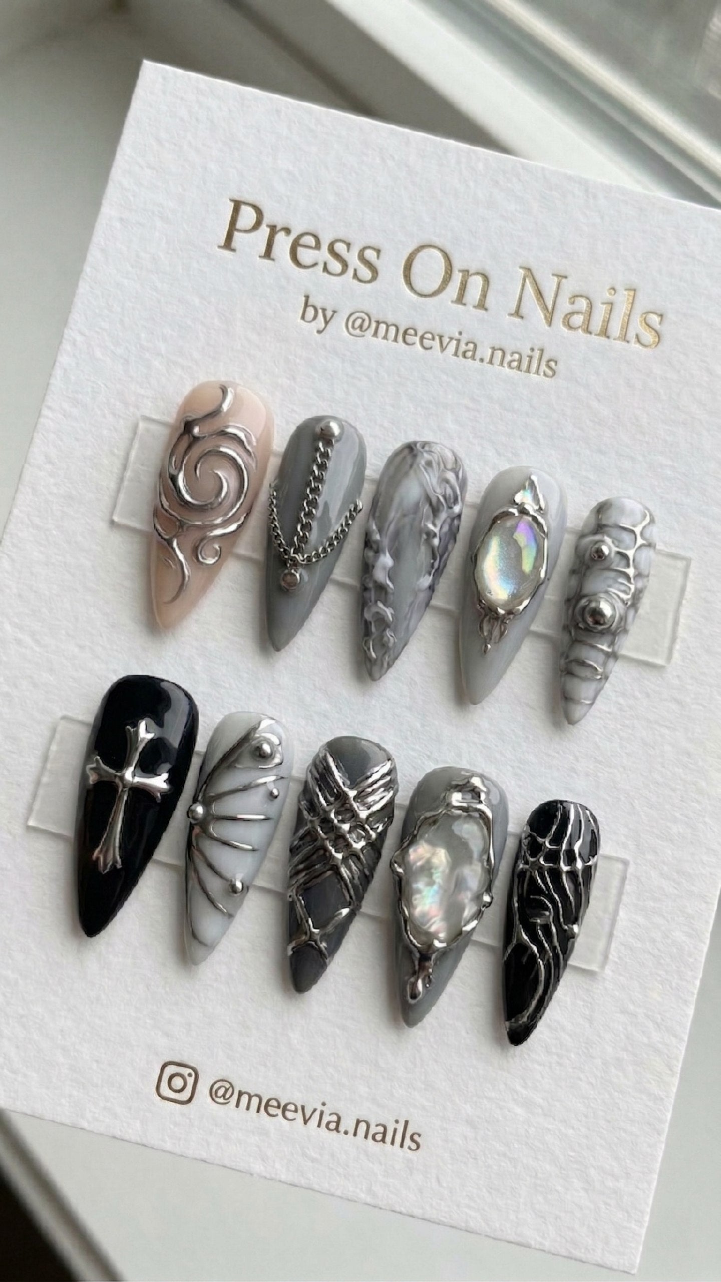 Stiletto-shaped gothic press-on nail set with silver 3D art, chains, and iridescent gems.