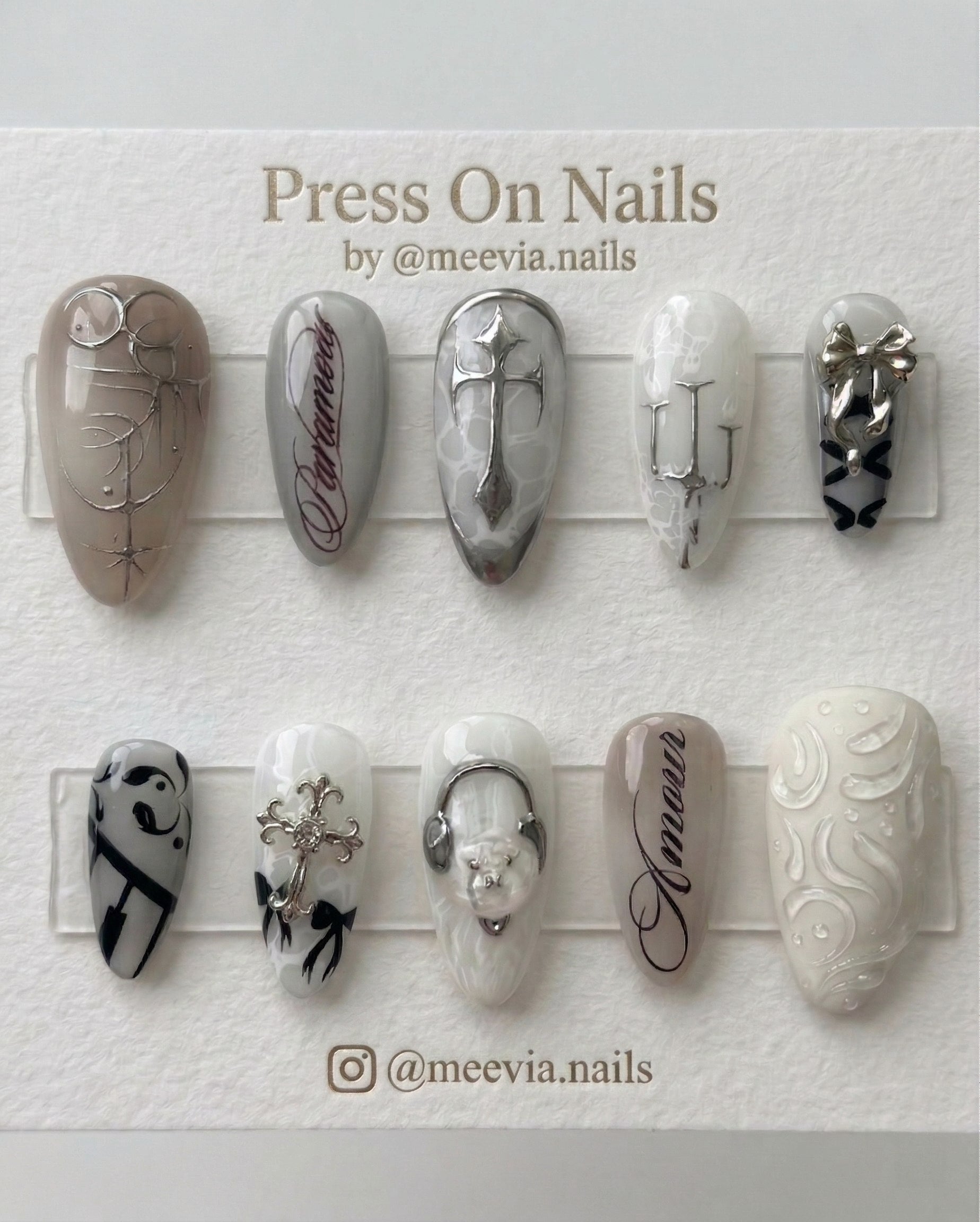 Stiletto-shaped gothic press-on nail set with silver chrome crosses, 3D bows, and script art