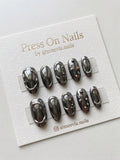 Oval-shaped gunmetal chrome press-on nail set with 3D liquid metal art and studs