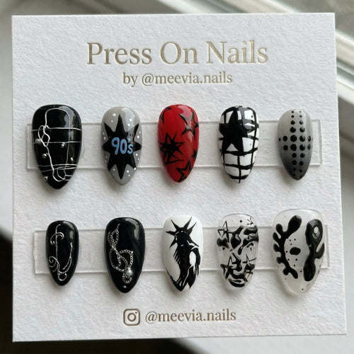 Stiletto-shaped 90s grunge press-on nail set with black stars, red accents, and 3D silver wire details.